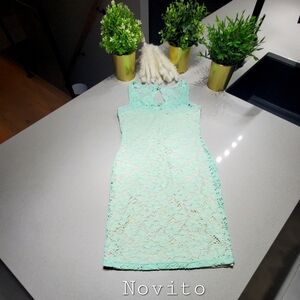 NOVITO Jolie robe en dentelle turquoise sur fond beige clair, longueur midi